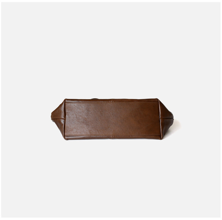 Grand sac unisex en cuir de vachette tanné végétal, taille petits et grands, porté épaule, coloris marron foncé, vue frontale de bas