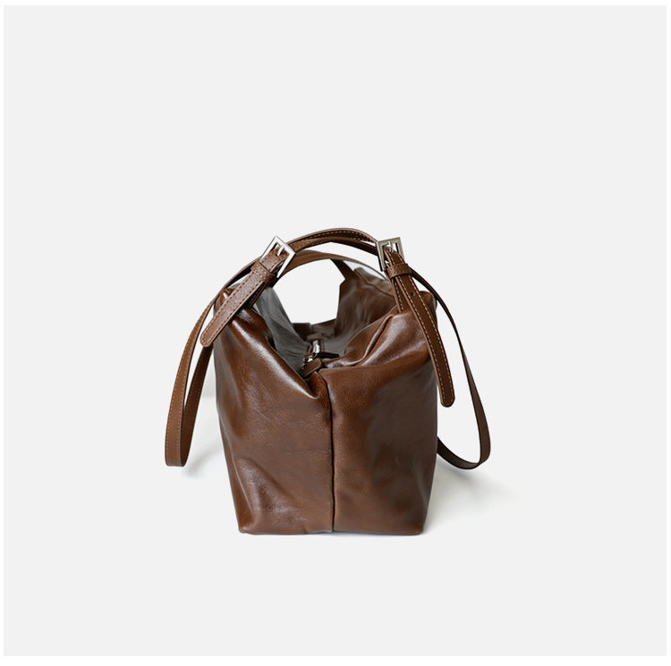Grand sac unisex en cuir de vachette tanné végétal, taille petits et grands, porté épaule, coloris marron foncé, vue frontale de coté